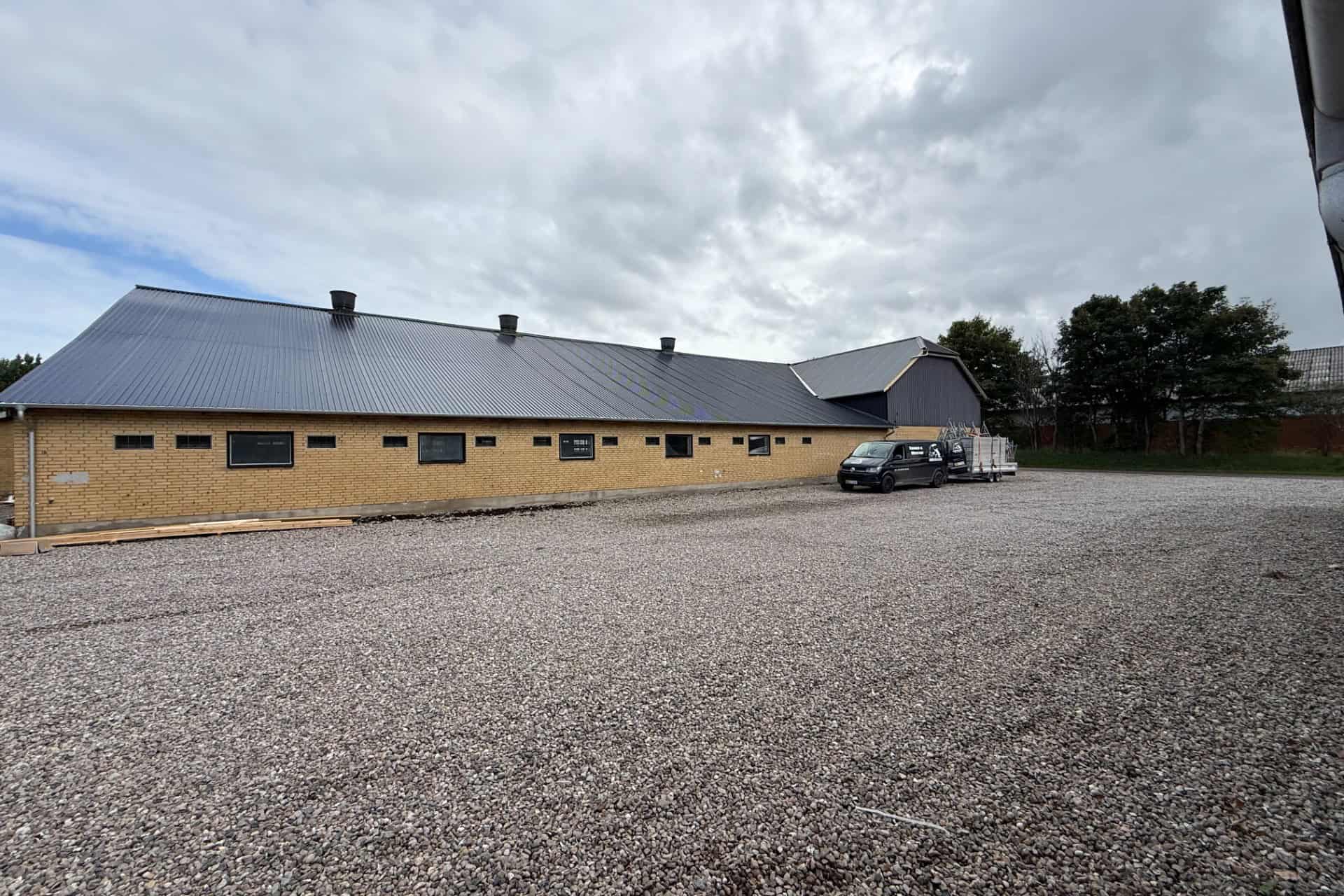 Lang gul bygning med nylagt mørkt tag i Sønderborg